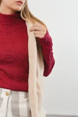 Sweater blanco de tejido de punto trenzado, con cuello alto y mangas largas.