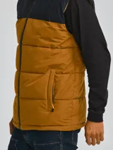 Chaleco acolchado Caterpillar con diseño bicolor en negro y marrón, cierre frontal completo, cuello alto y bolsillos laterales con cierre.
