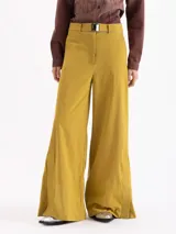 Pantalón de corte ancho y silueta relajada, confeccionado en tejido técnico con elasticidad. Presenta recortes verticales en el frente que finalizan en tajos en el ruedo y cuenta con un cinturón integrado con hebilla de enganche ajustable en la cintura.