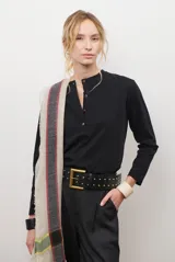 Remera de manga larga en color rosado, con cuello redondo y cierre frontal parcial con botones. Presenta un diseño de corte recto y estilo minimalista.