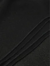 Chal negro de tejido suave y cálido, de estilo clásico y versátil.