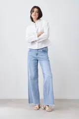 Camisa blanca de manga larga con cuello y puños bordados con calados. Corte clásico y cierre frontal con botones.