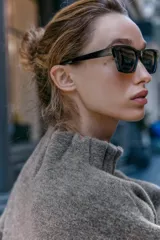 Chaqueta estilo bomber de punto color gris, con cuello subido, manga larga y acabados elásticos con frunces en puños y cuello. Cierre frontal con botones a presión ocultos.