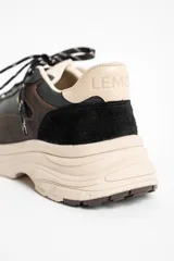 Zapatilla urbana de cuero con diseño de paneles en tonos negro, marrón oscuro y beige. Presenta una suela de plataforma robusta en color beige y cordones jaspeados.