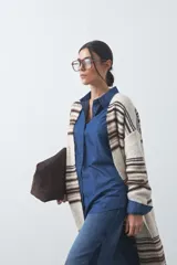 Cardigan largo de tejido de punto con diseño de rayas horizontales en tonos beige, marrón y blanco. Presenta una silueta relajada, mangas largas y frente abierto.