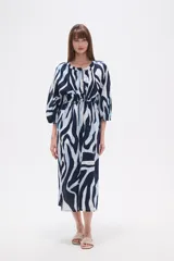 Vestido midi holgado con estampado de hojas en tonos verde y beige, cuello redondo con abertura en V y botones, y mangas 3/4 abullonadas.