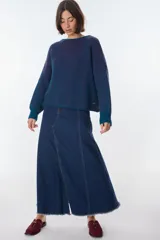 Sweater de punto a rayas verticales blancas y negras, con cuello redondo y mangas largas.