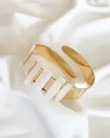 Brazalete rígido dorado con incrustaciones de piedra selenita.