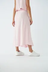 Falda midi abotonada en el frente, color rosa claro, con bolsillos laterales y diseño de corte recto.