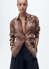 Camisa marrón con estampado paisley, de corte recto, cuello camisero y mangas largas con puños abotonados.