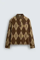 Polo de corte relajado confeccionada en tejido de textura con diseño de rombos en tonos marrones. Presenta cuello de solapa en pana, cierre frontal con botones, mangas largas con puños abotonados y bordado a contraste en el pecho.