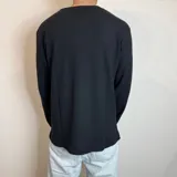 Buzo negro de micropanal con cuello redondo y mangas largas.