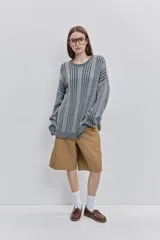 Sweater de punto color gris con diseño de rayas verticales oscuras, cuello redondo y calce relajado de mangas largas.
