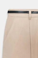 Pantalón tobillero de corte recto en color beige, con detalle de nervio delantero marcado. Incluye cinturón fino, bolsillos delanteros y cierre frontal con cremallera, botón interior y gancho.