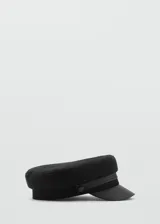 Gorro estilo baker boy de color negro, con diseño rígido y visera combinada en material sintético.