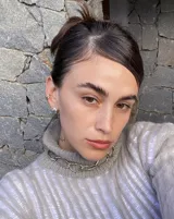 Aros pequeños de bronce con forma irregular y acabado liso, estilo huggie o argolla gruesa.