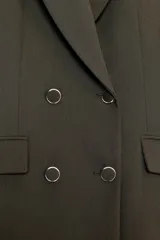 Blazer blanco de manga larga con cuello solapa y hombreras. Diseño cruzado con cierre frontal de cuatro botones y bolsillos delanteros con solapa.