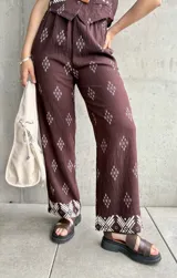 Pantalón marrón con estampado de rombos blancos y cintura elastizada.