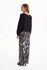 Blusa de viscosa color blanco con escote en V y cordón ajustable, mangas largas y volados decorativos en los hombros.