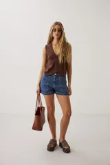 Short de denim azul de tiro medio, con bolsillos delanteros aplicados y dobladillo en las piernas.