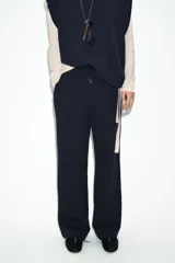 Pantalón de tiro medio confeccionado en tejido de punto elástico con pierna recta. Cuenta con cintura elástica ajustable mediante cordones y bolsillos laterales.