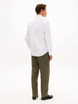 Camisa de manga larga con diseño de rayas verticales finas y corte clásico, confeccionada en algodón. Cuenta con cuello abotonado, cierre frontal con botones, un bolsillo de parche en el pecho con el logo bordado de la marca y puños con botones.