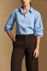 Pantalón de vestir negro de corte ancho y tiro alto, con silueta fluida y diseño minimalista.