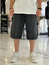 Bermuda de jean estilo carpintero, color celeste, con bolsillos laterales amplios, presilla para herramientas y diseño amplio de corte oversize.