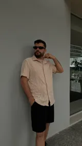 Camisa beige de crochet con cuello clásico y mangas cortas.