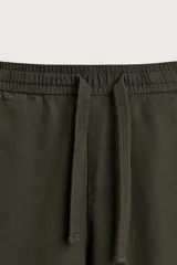 Pantalón de corte relajado confeccionado en una mezcla de algodón y lino. Presenta cintura elástica con cordón ajustable, bolsillos laterales y bolsillos traseros de vivo.