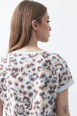 Remera de manga corta con estampado animal print en tonos blanco, marrón, beige y celeste.