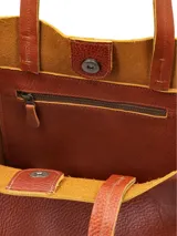 Cartera shopper de cuero color terracota, sin forro, con diseño amplio y asas de hombro.