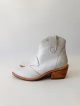 Botas texanas de cuero color gris claro, con caña baja, puntera cuadrada y taco de madera.