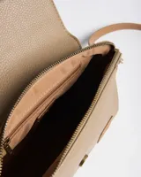Bandolera XL de símil cuero con textura granulada, solapa frontal con tira y hebilla, y correa ajustable y desmontable en tono suela. Cuenta con herrajes dorados envejecidos y el logo de la marca en relieve.
