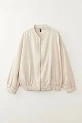 Campera tipo bomber color beige, confeccionada en tejido con lino. Presenta cierre frontal metálico, cuello redondo, bolsillos laterales y puños con elástico.