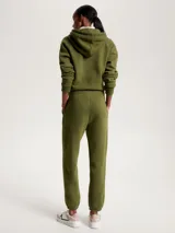 Pantalón de jogging verde militar, con cintura elástica, corte regular y pierna cónica. Presenta un logo universitario aterciopelado de Tommy Hilfiger en la pierna izquierda.