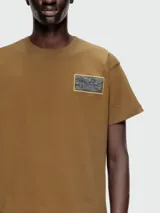 Remera de algodón color marrón con cuello redondo y parche rectangular con logo Diesel estampado en el pecho.