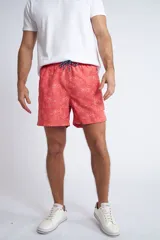 Short de baño con cintura elástica y cordón ajustable, confeccionado en tela ligera de secado rápido. Presenta un estampado botánico integral en tonos amarillos, blancos y azules, con dos bolsillos delanteros y uno posterior.