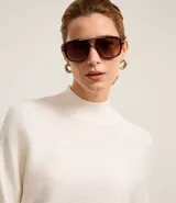 Blusa de punto acanalado color tostado, con cuello alto, mangas largas y puños ajustados. Confeccionada en viscosa, poliéster y poliamida.