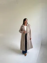 Tapado largo de paño en color beige, con solapas anchas, cierre frontal de un botón y diseño estructurado.