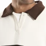 Buzo de estilo rugby con cuello camisero en contraste color crema, confeccionado en algodón y poliéster. Presenta una franja horizontal azul en el pecho con el logo de la marca estampado y diseño de manga larga.