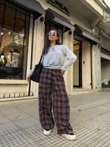 Pantalón de corte holgado tipo barrel con diseño de cuadros en tonos bordó, negro y blanco. Confeccionado en tela viyela, cuenta con cintura elástica y puños ajustados en los tobillos.