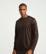 Remera deportiva de manga larga para hombre, confeccionada en tejido Dry Fit color marrón con sutiles rayas y detalles reflectantes en los hombros. Cuenta con cuello redondo y diseño cómodo para entrenamiento.