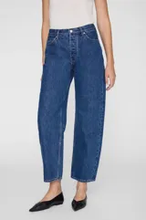 Jean de denim azul de tiro alto, con silueta barrel de pierna curva y diseño clásico de cinco bolsillos.