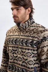 Buzo de sherpa con medio cierre frontal, cuello alto y estampado geométrico abstracto en tonos beige, marrón y negro.