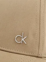 Gorra de béisbol color beige con logo metálico de Calvin Klein en el lateral.