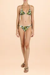 Bombacha de bikini con estampado animal print en tonos verdes sobre fondo turquesa, con tiras laterales ajustables mediante lazadas.
