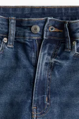 Jean de tiro alto y corte skinny, en denim azul con efecto deslavado y sutil elasticidad. Presenta diseño clásico de cinco bolsillos, trabillas para cinturón y cierre frontal con botón y cremallera.