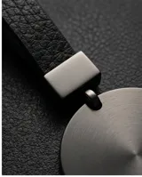 Llavero de diseño minimalista con dije circular de metal en acabado negro mate y argolla metálica a juego.
