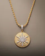 Collar de la línea Imperial, compuesto por una cadena de eslabones tipo cuerda en color dorado y un gran dije redondo con textura punteada y un diseño central de estrella incrustado de piedras brillantes.